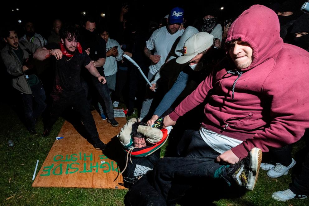 PHOTO: A pro-Palestinian demonstrator is beaten by counter protesters attacking a pro-Palestinian encampment set up on the campus of the University of California Los Angeles as clashes erupt, in Los Angeles on May 1, 2024.