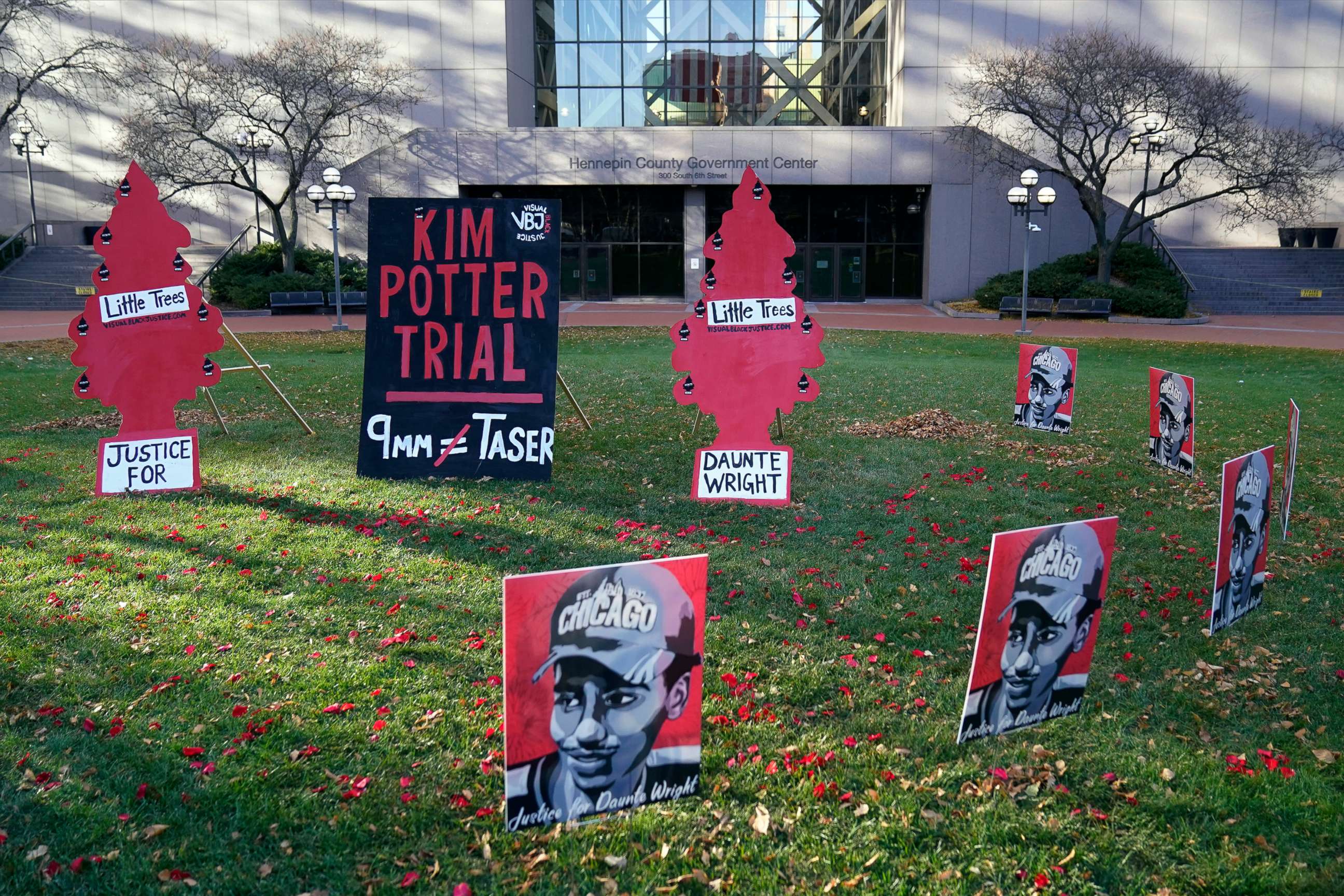 PHOTO: Signs stand on the south lawn, Nov. 30, 2021, at the Hennepin County Government Center in Minneapolis where jury selection begins for former police officer Kim Potter, who shot and killed motorist Daunte Wright.