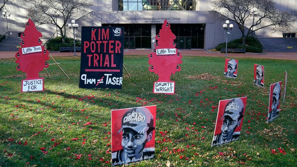 PHOTO: Signs stand on the south lawn, Nov. 30, 2021, at the Hennepin County Government Center in Minneapolis where jury selection begins for former police officer Kim Potter, who shot and killed motorist Daunte Wright.