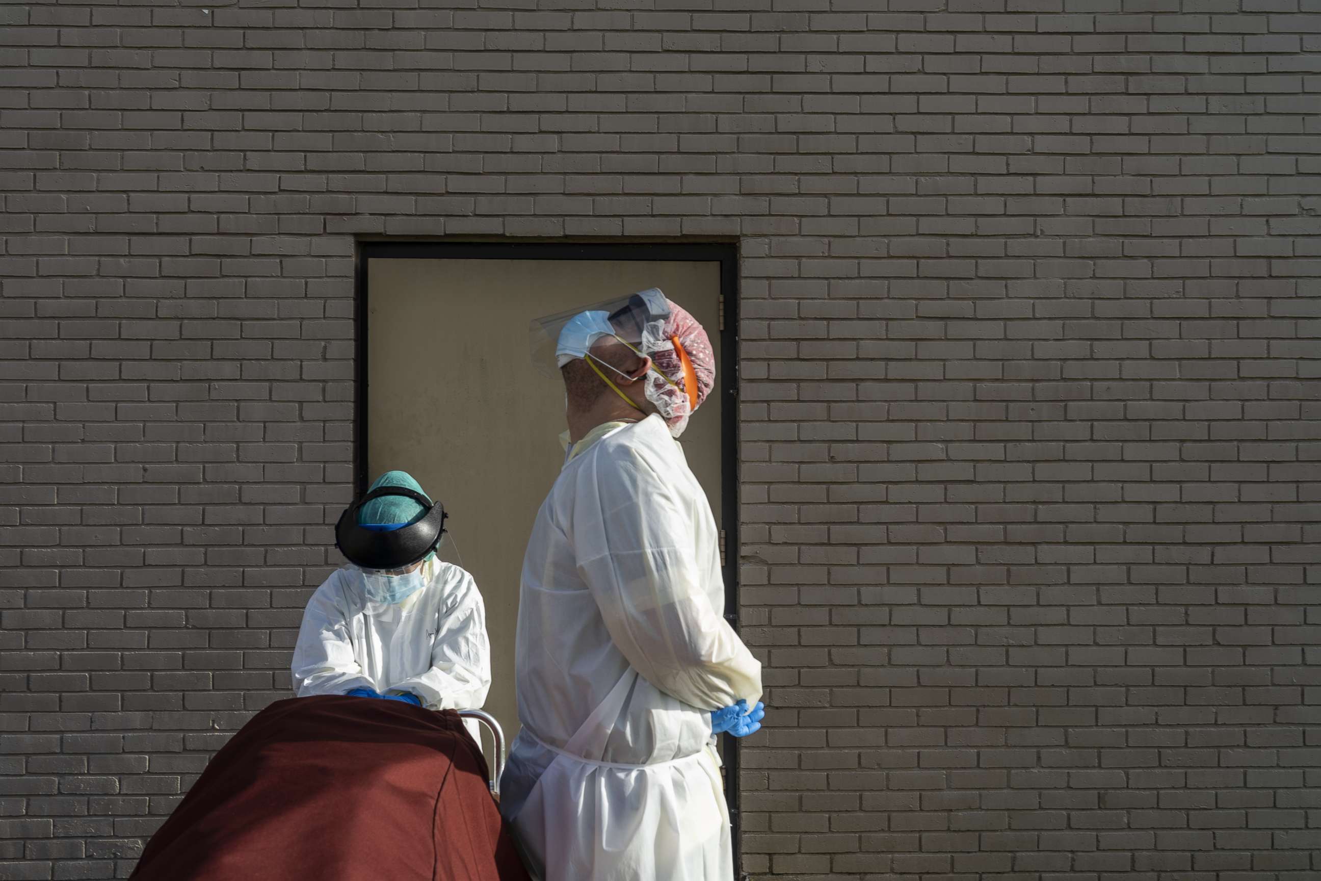 PHOTO: Medical staff wearing full PPE wait for a car to pick up a deceased patient outside of  the Covid-19 intensive care unit at the United Memorial Medical Center on June 30, 2020 in Houston, Texas.