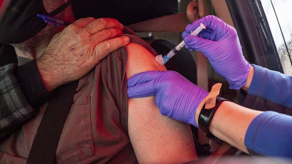 PHOTO: A healthcare worker administers a dose of the Moderna COVID-19 vaccine to a person in a vehicle at a drive-thru vaccination site at the Meigs County fairgrounds in Pomeroy, Ohio, March 18, 2021. 