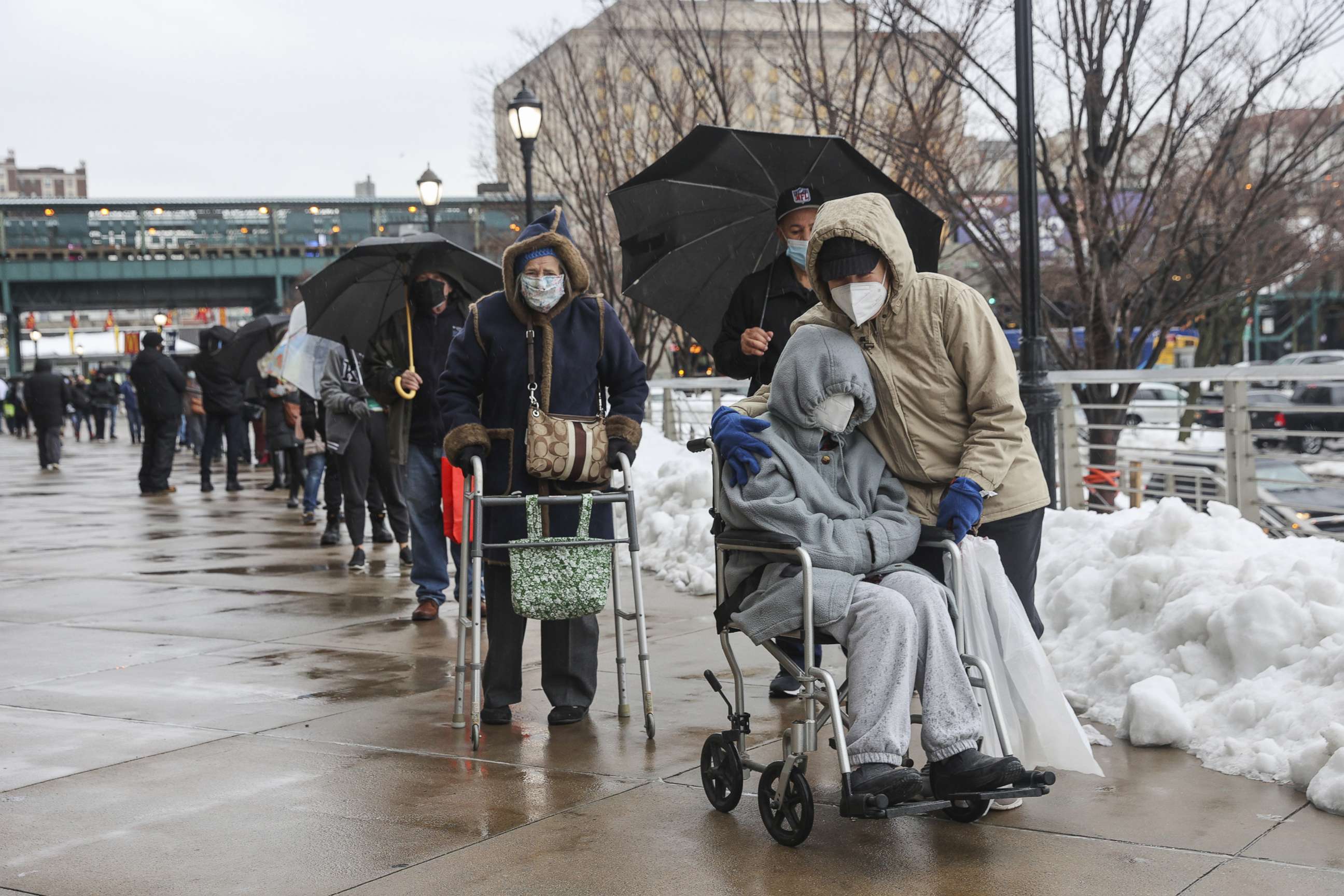 PHOTO: People wearing protective masks line up outside a COVID-19 vaccination hub inside Yankee Stadium in New York, Feb. 5, 2021. 