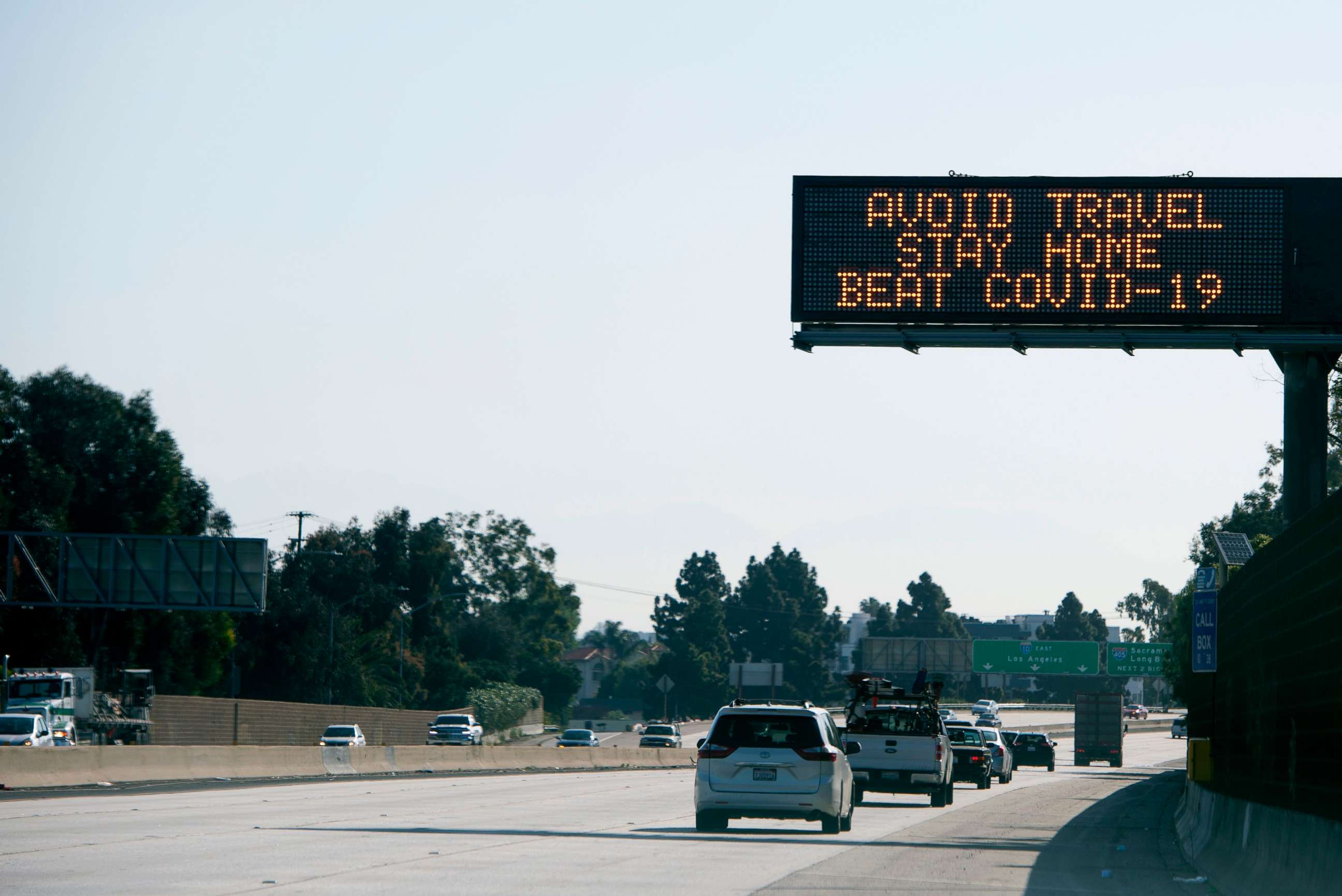 PHOTO: A sign asking for drivers to "avoid travel and stay home" due to the spread of the COVID-19, the disease caused by the novel coronavirus, is displayed over the I-10 freeway in Santa Monica, California, on April 14, 2020.
