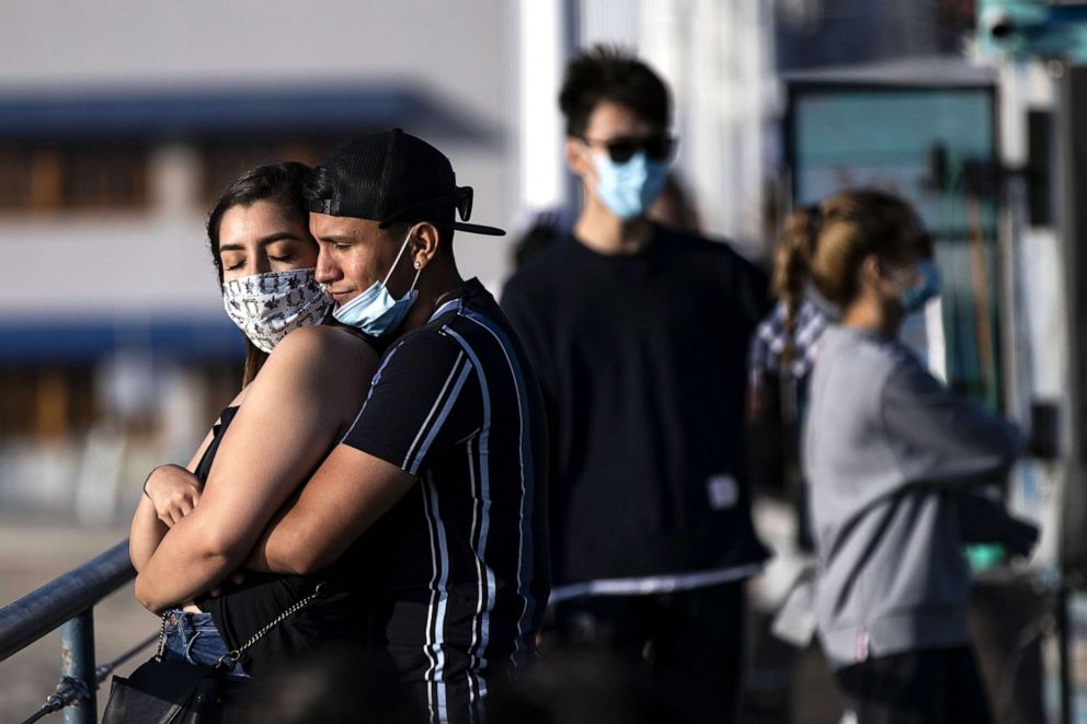 PHOTO: A couple embrace each other on the Santa Monica Pier amid the coronavirus pandemic in Santa Monica, Calif., June 25, 2020.
