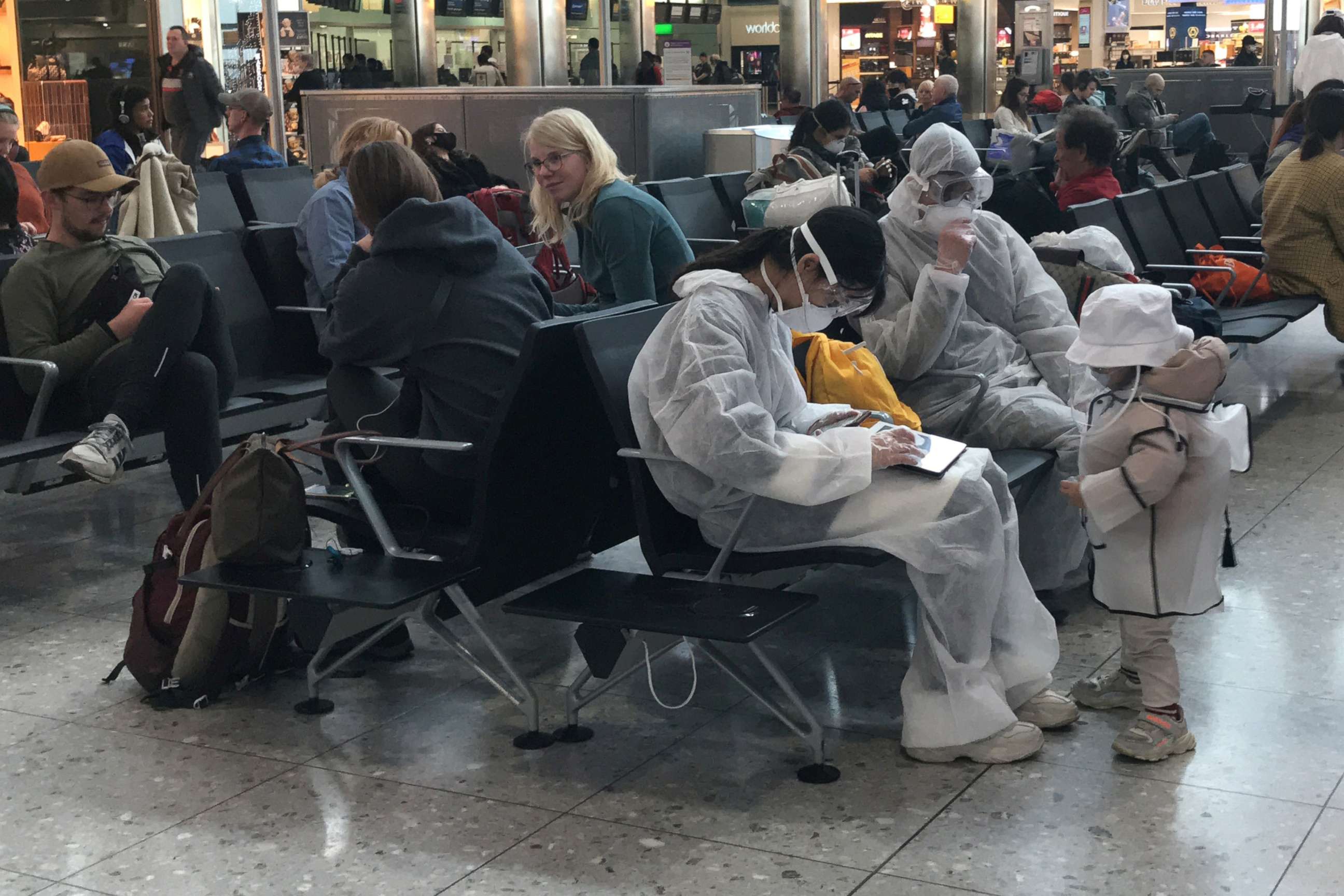 PHOTO: A group of travellers wear protective clothing in the departure lounge at Heathrow Airport Terminal 2 in London, March 19, 2020. 