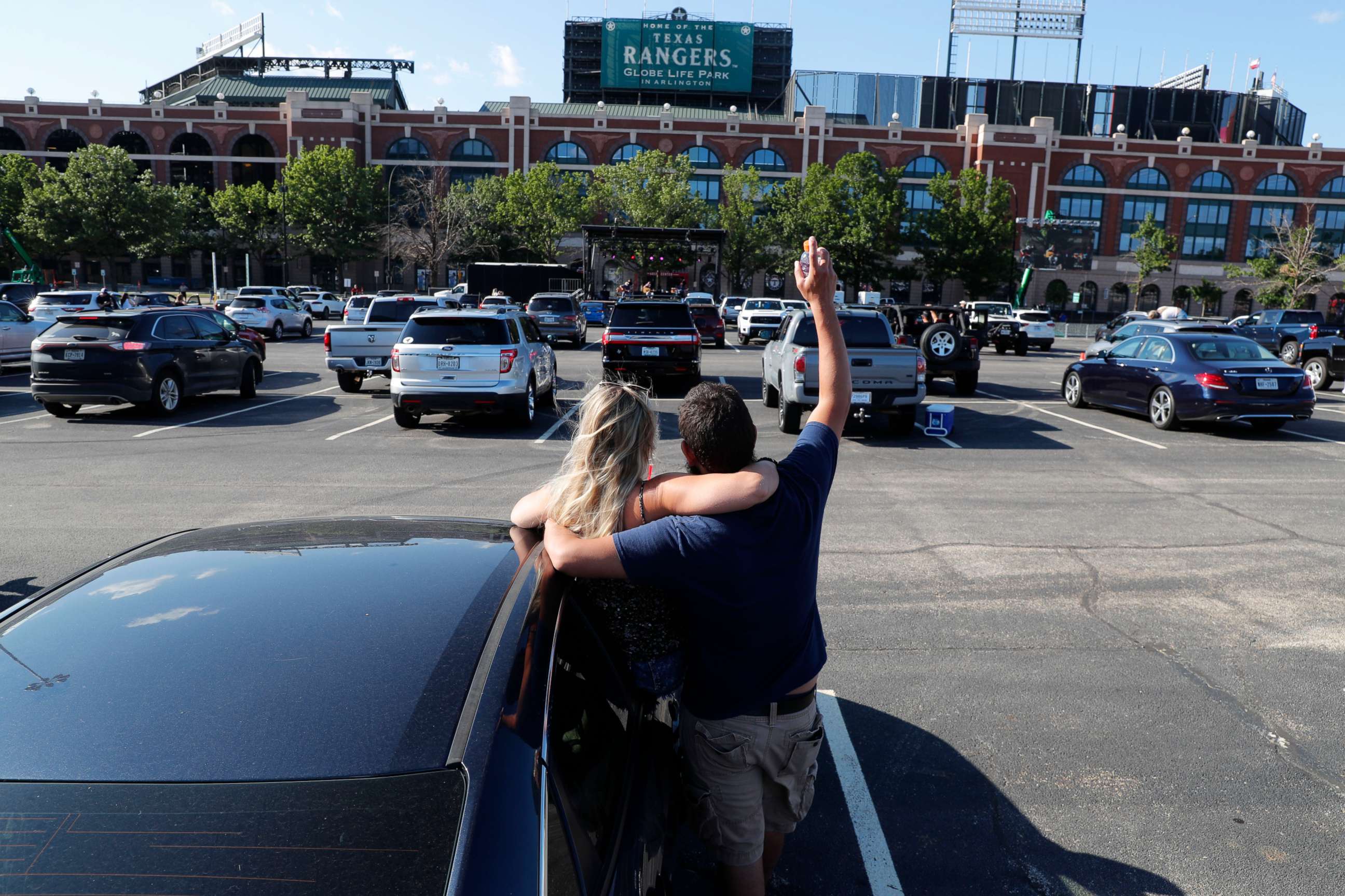 PHOTO: David Del Puerto, right, cheers with his date Missy Croyl while watching a concert from their vehicle parked with social distancing in mind outside of Globe Life Field in Arlington, Texas, June 4, 2020.