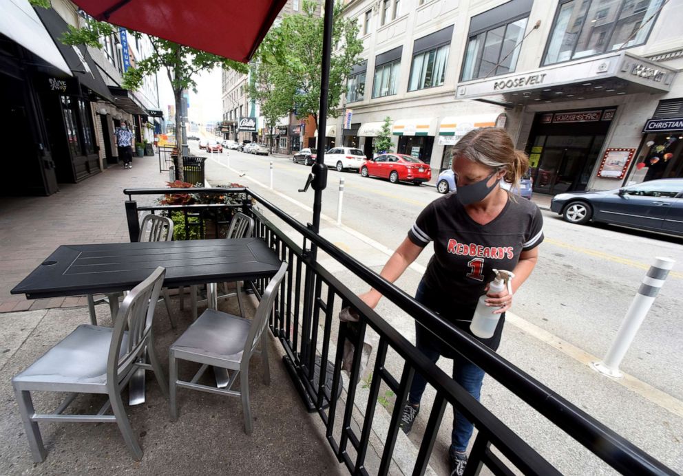 PHOTO: Heather Harper, of Bellevue, cleans the railing and dining area in front of RedBeards on Sixth Street, Monday, June 22, 2020, in the Cultural District of Downtown Pittsburgh.