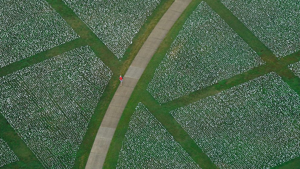 PHOTO: A visitor walks past artist Suzanne Brennan Firstenberg's "In America: Remember," a temporary art installation made up of white flags to commemorate Americans who have died of COVID-19, on the National Mall in Washington, Sept. 22, 2021.