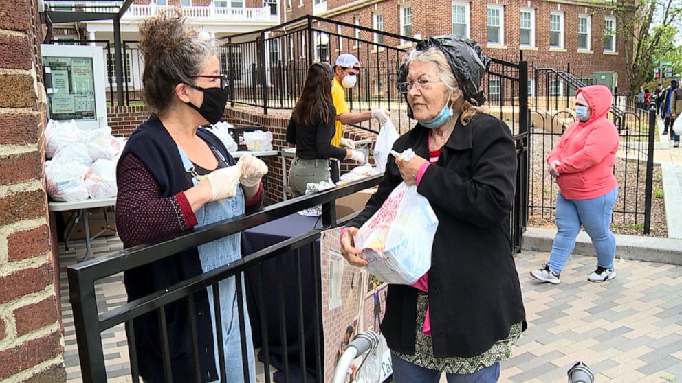 PHOTO: A Martha's Table volunteer hands out a bag of food to a DC resident in need.
