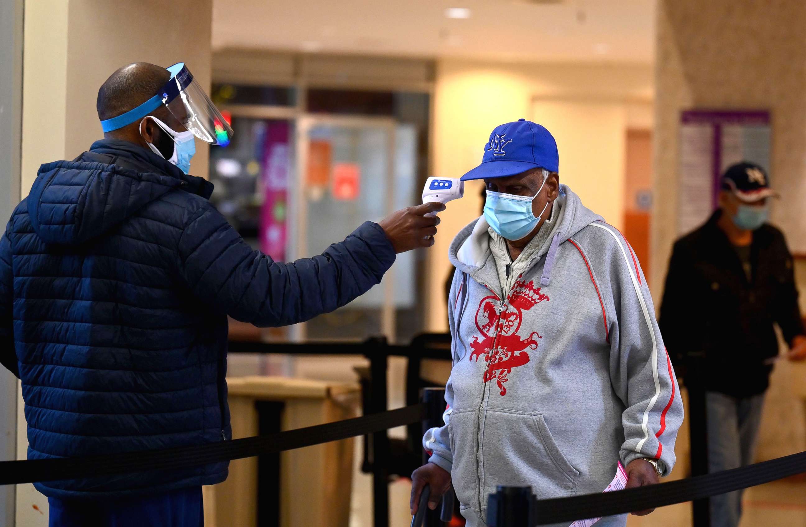 PHOTO: A staff member checks the temperature of a visitor at Woodhull Medical and Mental Health Center, Dec. 1, 2020, in New York.