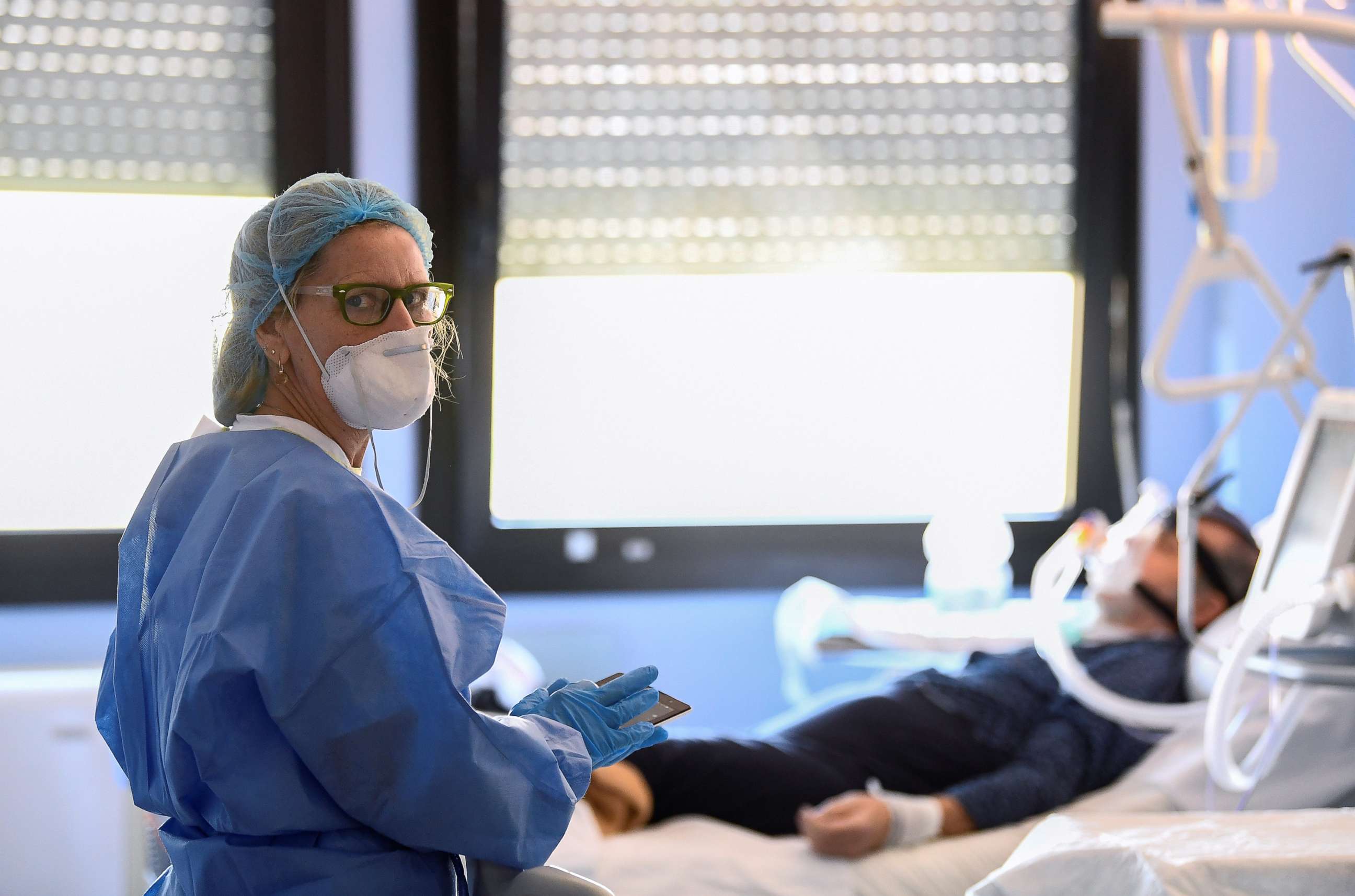 PHOTO: A medical worker wearing a protective mask and suit looks on as she treats a patient suffering from coronavirus disease (COVID-19) in an intensive care unit at the Oglio Po hospital in Cremona, Italy, March 19, 2020. 