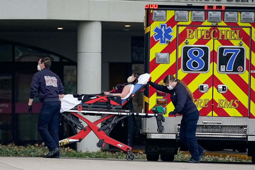 PHOTO: Emergency medical personnel transport a patient into the emergency department of Norton Women's and Children's Hospital, as all wear masks to avoid the spread of the novel coronavirus disease (COVID-19) in Louisville, Ky., March 24, 2020.