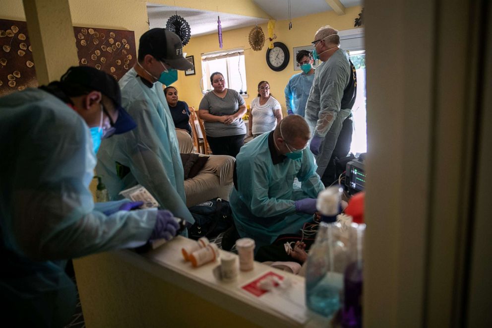 PHOTO: Houston Fire Department EMS medics prepare to transport a man with possible COVID-19 symptoms to a hospital on Aug. 11, 2020, in Houston.