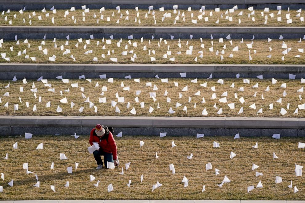 PHOTO: A man places flags at the National World War I Museum and Memorial, Jan. 19, 2021, in Kansas City, Mo.