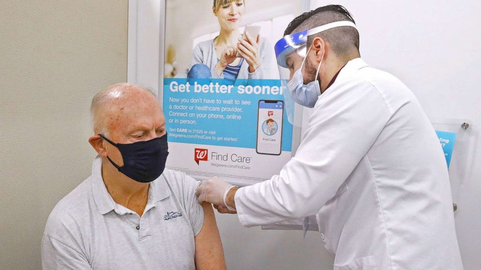 PHOTO: A man is given his vaccination by pharmacist Joe Borge inside the Walgreens Pharmacy, at 107 High Street, in Danvers, Mass., Feb. 1, 2021.