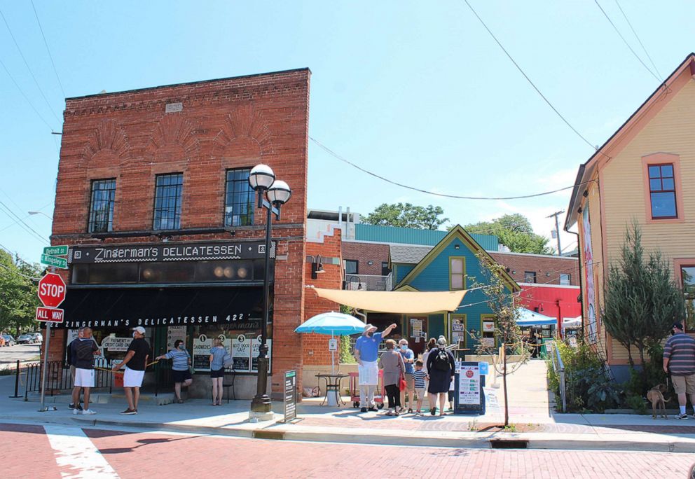 PHOTO: People stand outside Zingerman's Delicatessen in Ann Arbor, Mich., during the coronavirus pandemic in 2020.