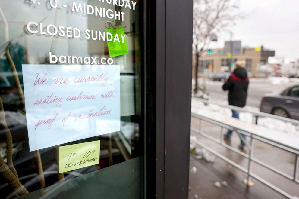 PHOTO:  A sign in the window at Bar Max reads, We are currently seating customers with proof of vaccination in Denver, Colo., April 16, 2021.