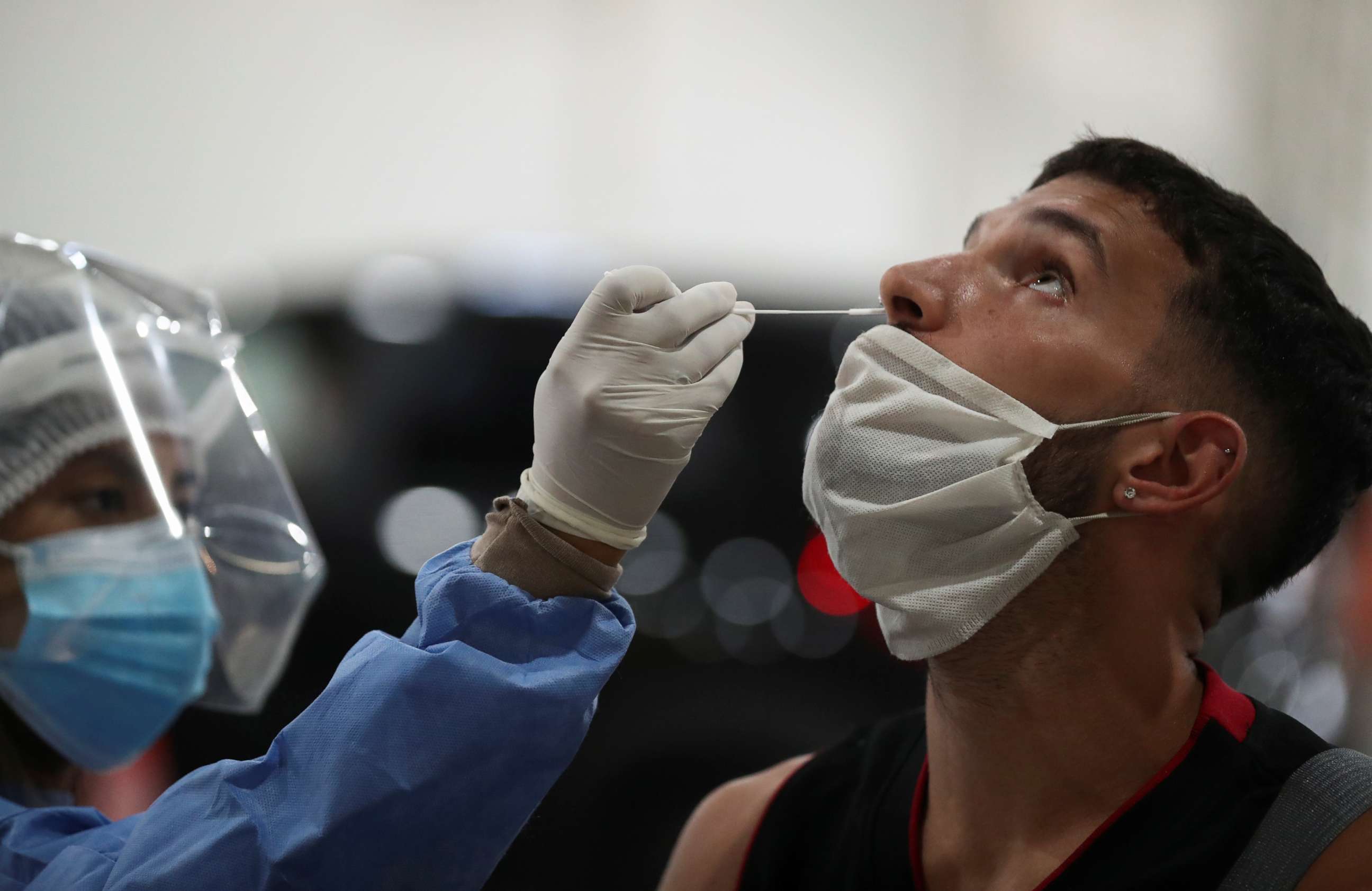 PHOTO: A healthcare worker takes a swab sample from a man to be tested for the coronavirus disease (COVID-19), in Buenos Aires, Argentina April 6, 2021. Picture taken April 6, 2021. 