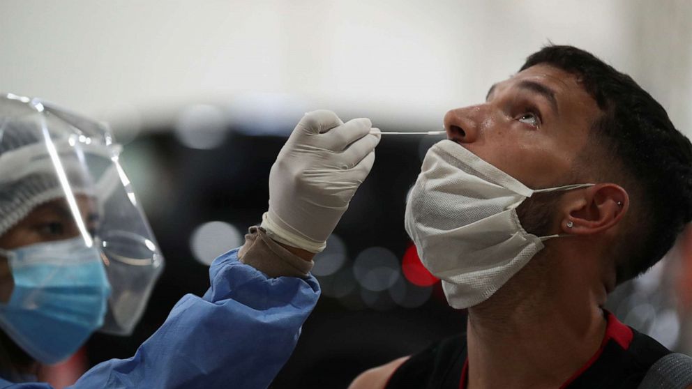 PHOTO: A healthcare worker takes a swab sample from a man to be tested for the coronavirus disease (COVID-19), in Buenos Aires, Argentina April 6, 2021. Picture taken April 6, 2021. 