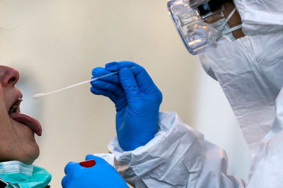 PHOTO: Medical staff of a mobile unit take samples from a woman to test for Covid-19, at the Santa Maria della Pieta' hospital complex, in Rome, April 1, 2020. 