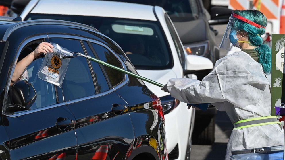 PHOTO: A health worker collects a self-administered COVID-19 test at a drive-thru testing site in Los Angeles, California, on Nov. 30, 2020.