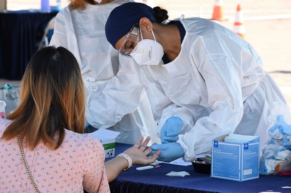 PHOTO: A person undergoes a finger prick blood sample as part of a coronavirus antibody rapid serological test, July 26, 2020, in San Dimas, California.