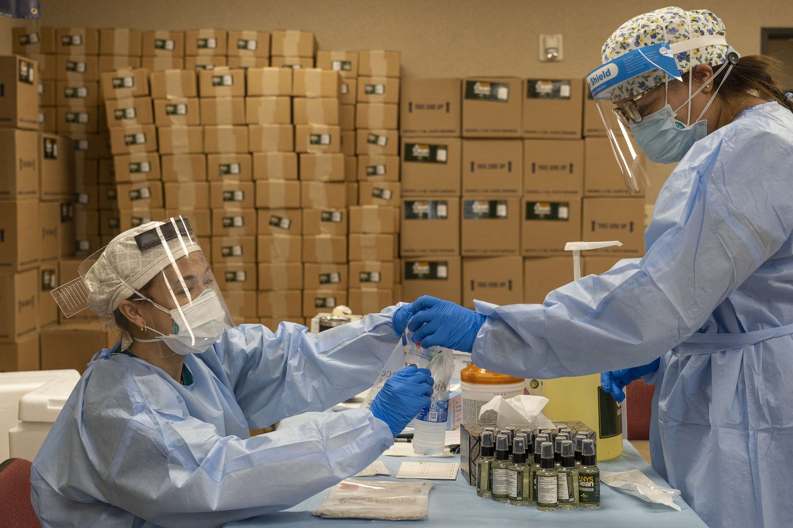 PHOTO: Medical workers from New York wearing personal protective equipments handle test samples at temporary testing site for COVID-19 in Higher Dimensions Church, July 17, 2020, in Houston.