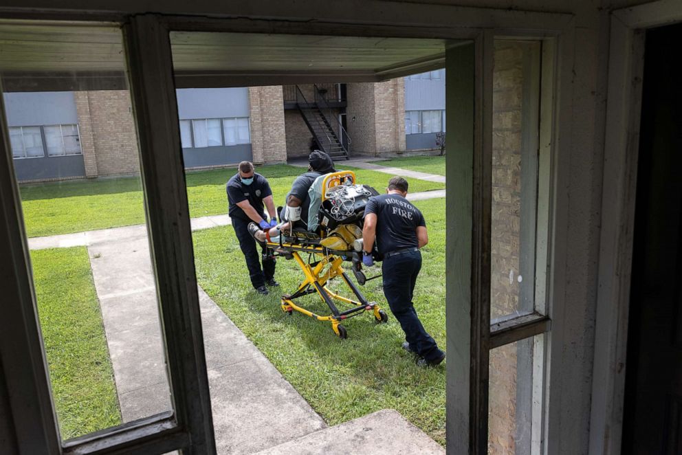 PHOTO: Houston Fire Department medics transport a woman who earlier tested positive for COVID-19 to a hospital for treatment on Aug. 20, 2021, in Houston.