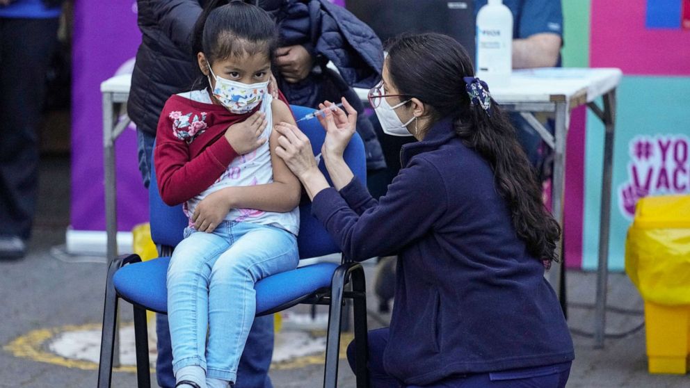 PHOTO: A healthcare worker inoculates a child with a dose of the Coronavac COVID-19 vaccine at the Providencia school in Santiago, Chile, Sept. 27, 2021, during the start of vaccinations in schools for children, age 6 to 11.