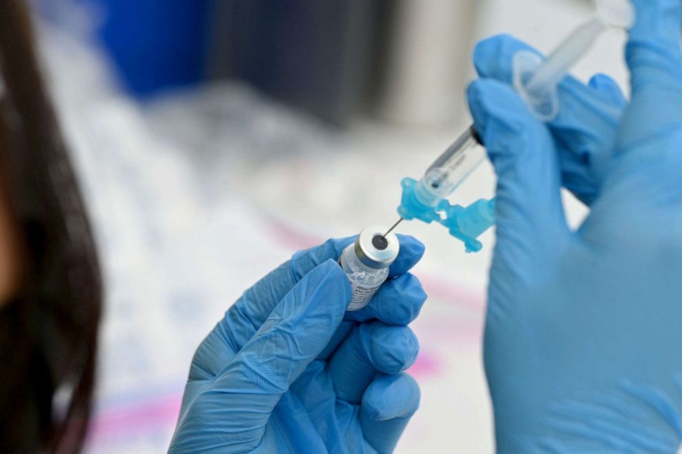 PHOTO: A healthcare worker fills a syringe with Pfizer Covid-19 vaccine at a community vaccination event in a predominately Latino neighborhood in Los Angeles, California, August 11, 2021. 