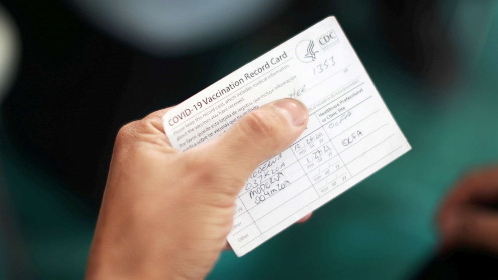 PHOTO: An Orange County firefighter holds his vaccination card after receiving the coronavirus disease vaccine in Irvine, Calif., Jan. 27, 2021.