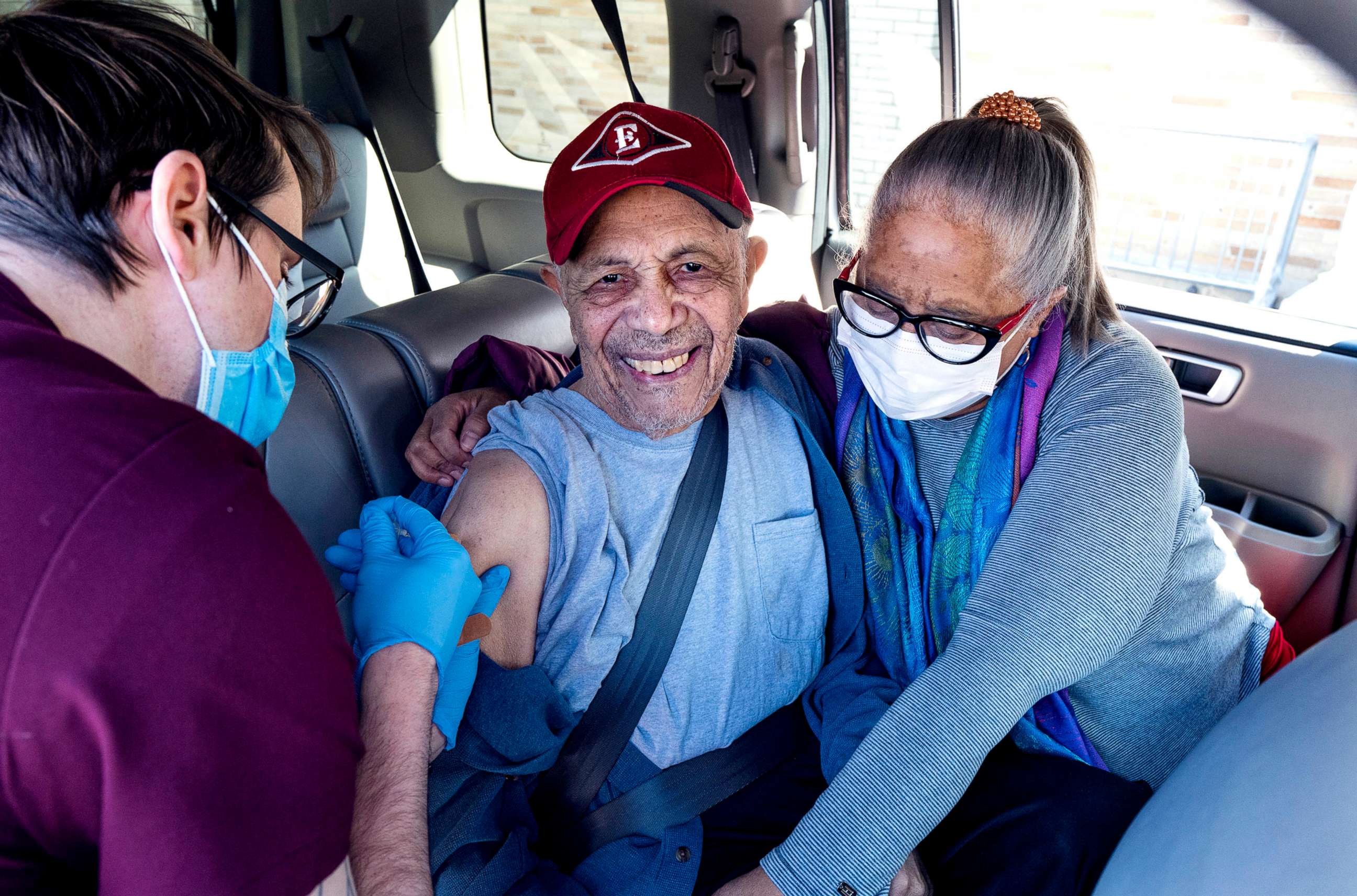 PHOTO: Andres Garcia, 90, guided by his daughter Irma Garcia, is vaccinated in the back seat of their car in Binghamton, N.Y., March 19, 2021.