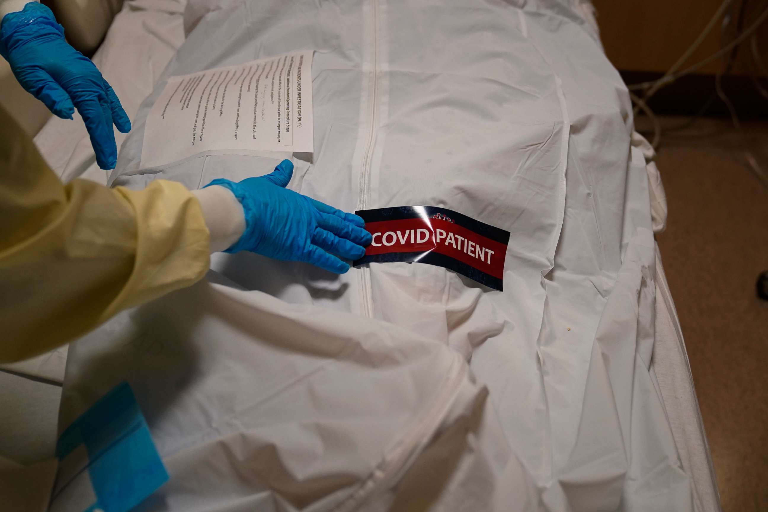 PHOTO: A health care worker places a "COVID Patient" sticker on a body bag holding a deceased patient at Providence Holy Cross Medical Center in the Mission Hills neighborhood of Los Angeles, California, on Jan. 9. 2021.