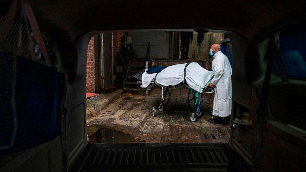 PHOTO: Maryland Cremation Services transporter Reggie Elliott brings the remains of a COVID-19 victim to his van from the hospital's morgue in Baltimore, Maryland, on Dec. 24, 2020.