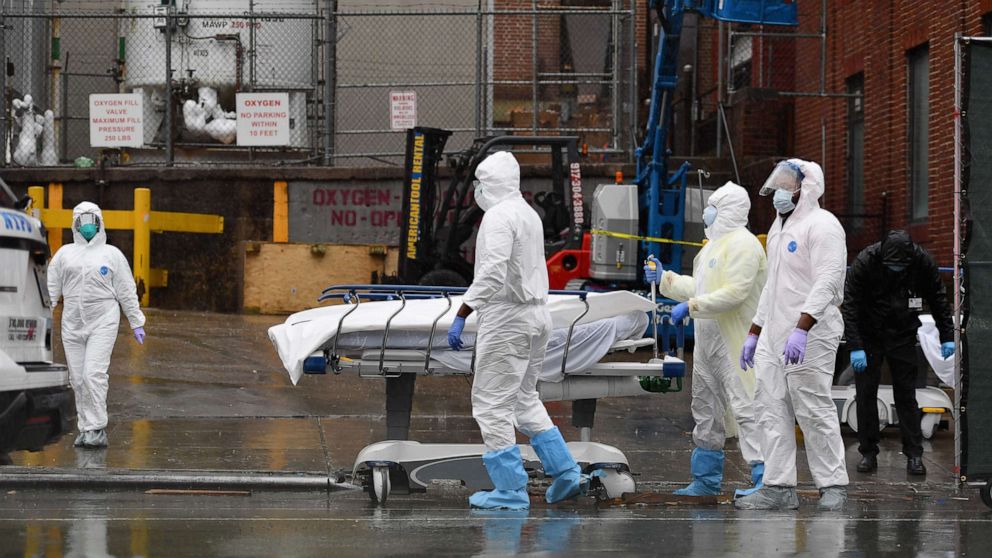 PHOTO: In this file photo taken on April 09, 2020, medical personnel move a deceased patient to a refrigerated truck serving as a makeshift morgue at The Brooklyn Hospital Center in New York City.