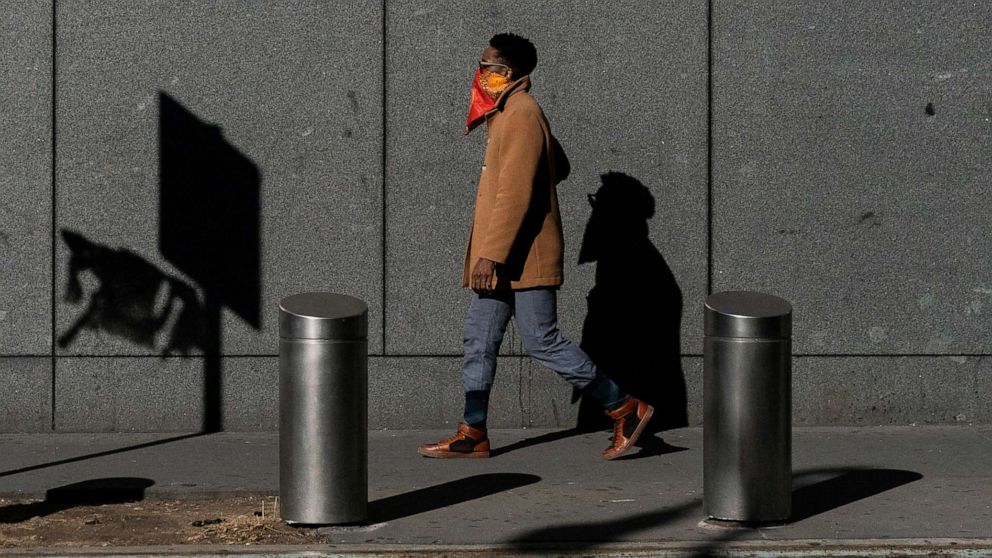 PHOTO: A man covers his face while walking on the streets in the Manhattan borough, following the outbreak of the coronavirus disease (COVID-19), in New York, March 15, 2020. 