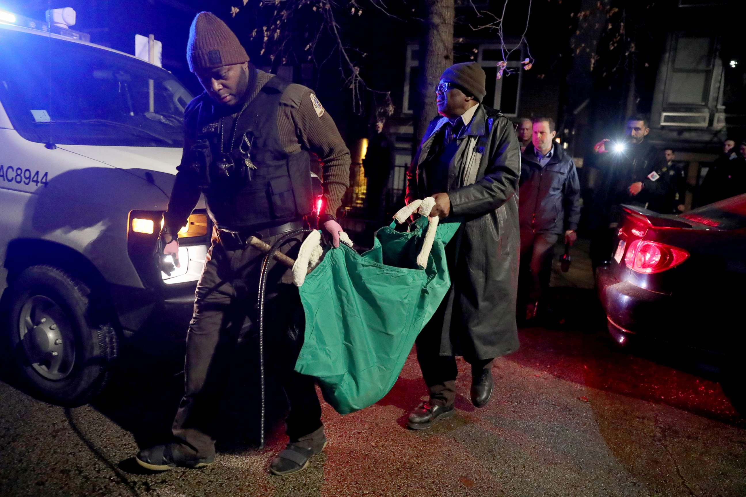 PHOTO: A Chicago police officer and a Chicago Animal Care and Control worker carry a coyote out in a green bag after tranquilizing the animal behind a home, Jan. 9, 2020.