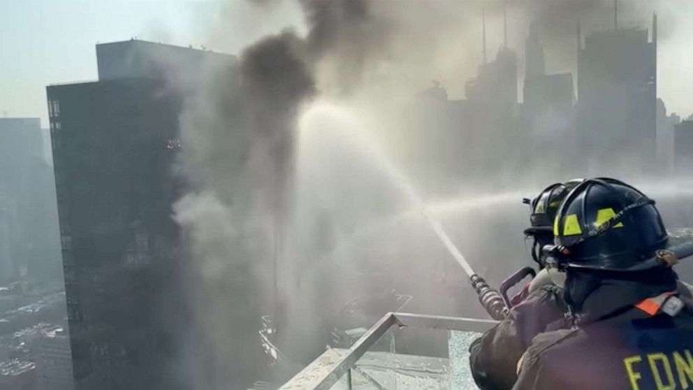 PHOTO: FDNY spray water on a construction crane that caught fire on a high-rise building in Manhattan, New York City, July 26, 2023.