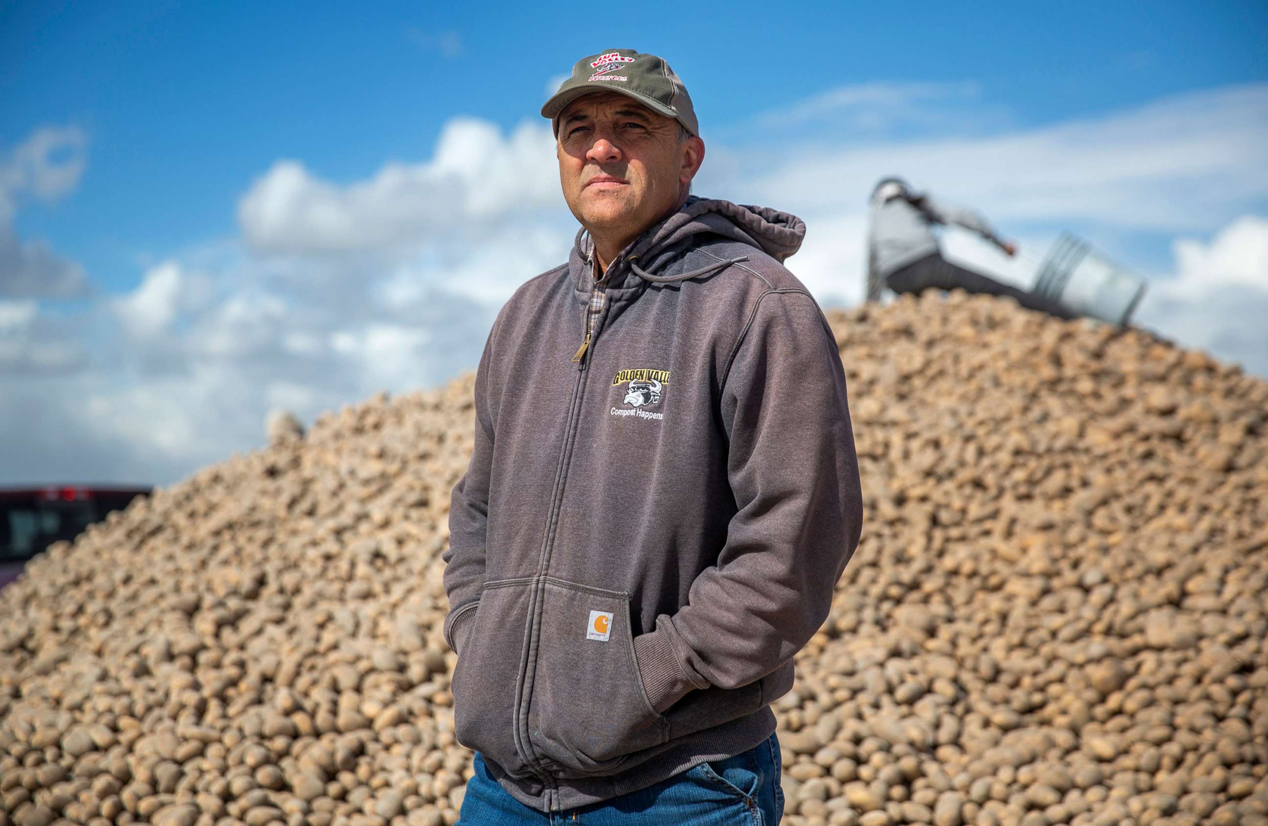 PHOTO: Ryan Cranney poses for a portrait next to a mound of potatoes he's made free to the public, April 15, 2020, at his farm in Oakley, Idaho.