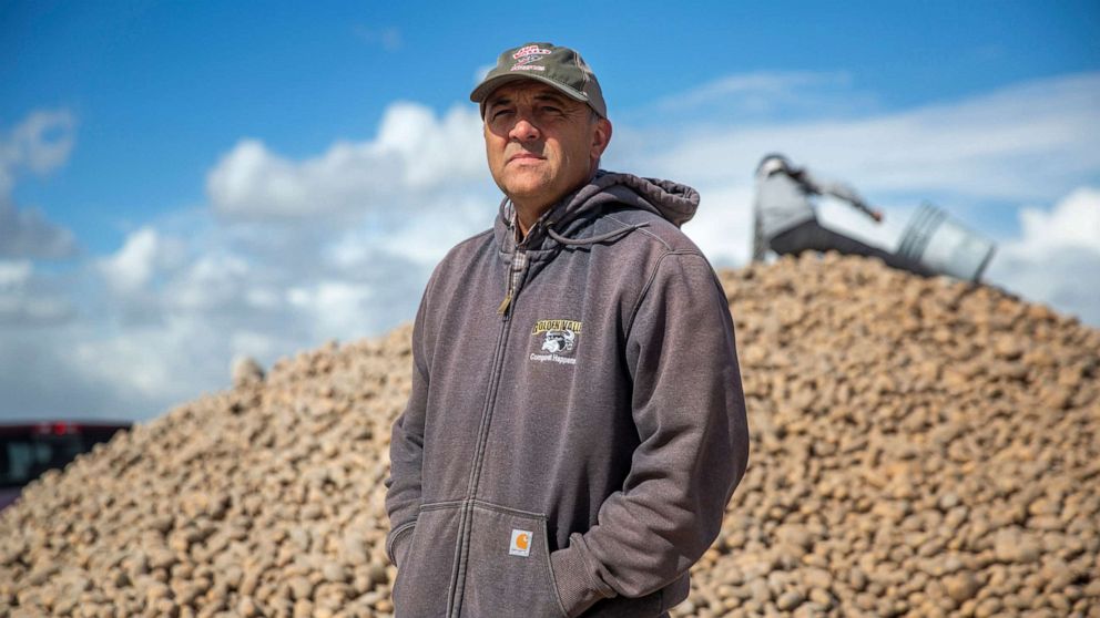 PHOTO: Ryan Cranney poses for a portrait next to a mound of potatoes he's made free to the public, April 15, 2020, at his farm in Oakley, Idaho.