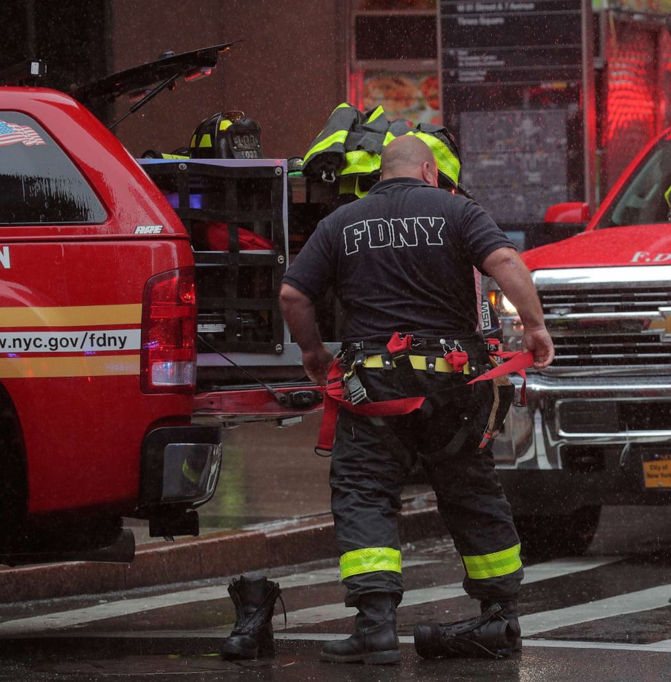 PHOTO: New York City firefighters suit up at the scene after a helicopter crashed atop a building and caused a fire in the Manhattan borough of N.Y., June 11, 2019.