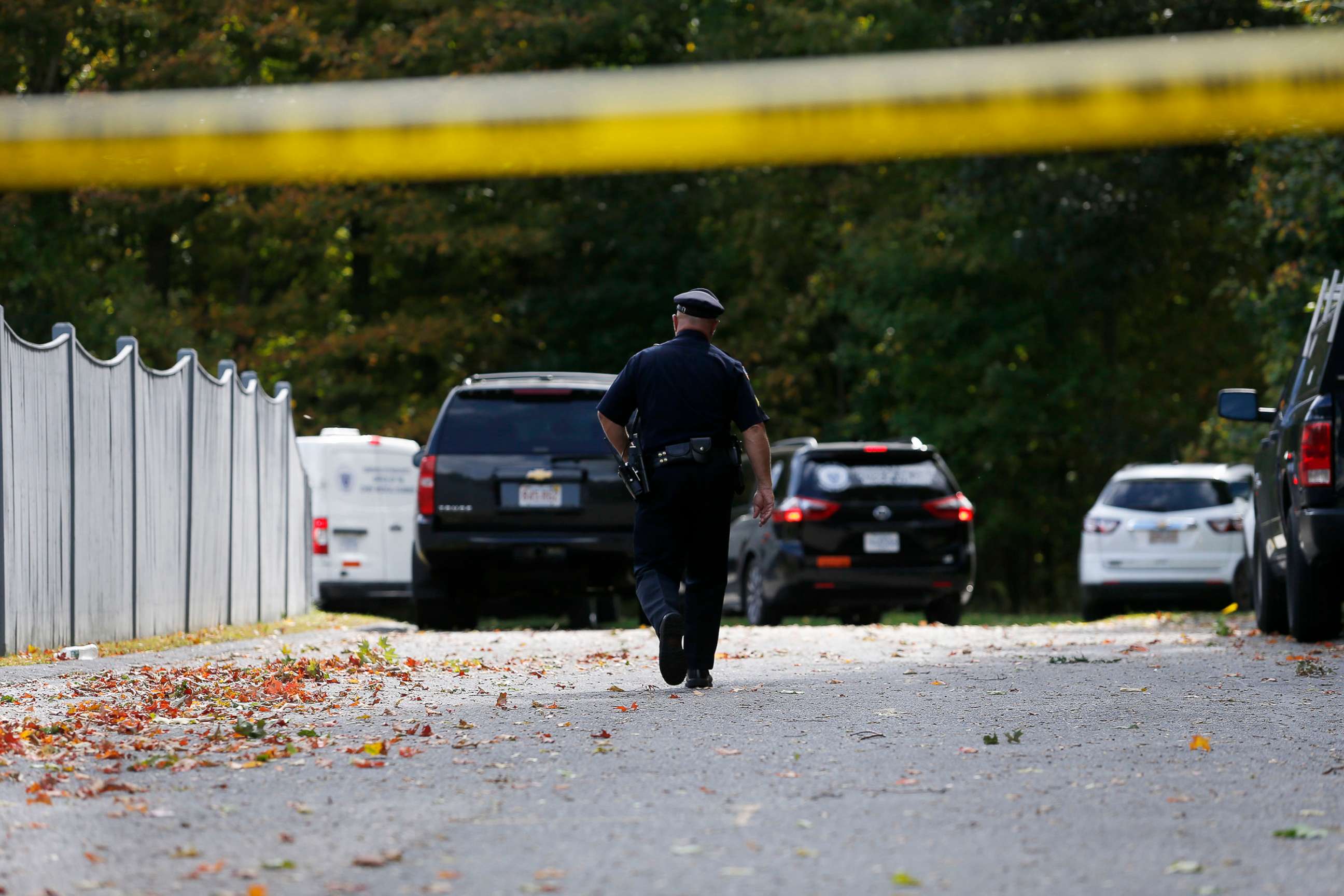 PHOTO: An officer walks towards Medical Examiners office vans as they enter the scene where three children and two adults were found deceased in their home in Abington, Mass. on Oct. 7, 2019.
