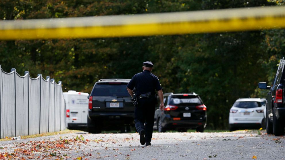 PHOTO: An officer walks towards Medical Examiners office vans as they enter the scene where three children and two adults were found deceased in their home in Abington, Mass. on Oct. 7, 2019.