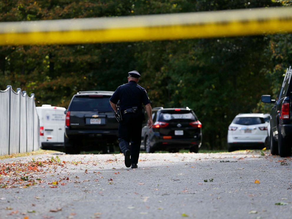 PHOTO: An officer walks towards Medical Examiners office vans as they enter the scene where three children and two adults were found deceased in their home in Abington, Mass. on Oct. 7, 2019.