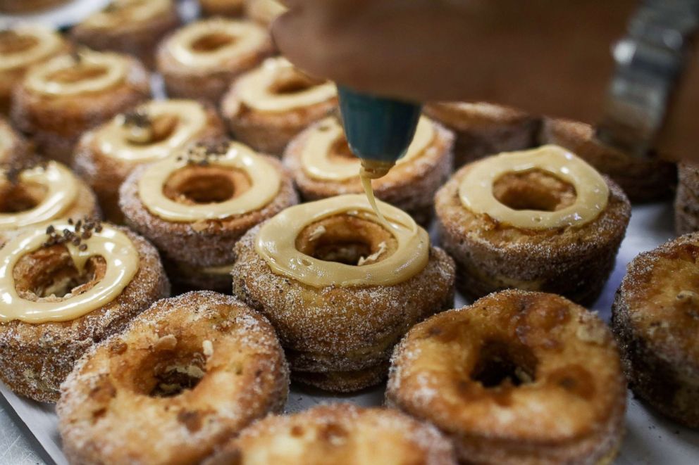 PHOTO: Bakers pipe icing onto Cronuts ahead of the opening of the Dominique Ansel Bakery in London, Sept. 30, 2016.