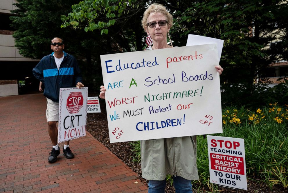 PHOTO: People hold up signs during a rally against "critical race theory" (CRT) being taught in schools outside the Loudoun County Government center in Leesburg, Va. on June 12, 2021.