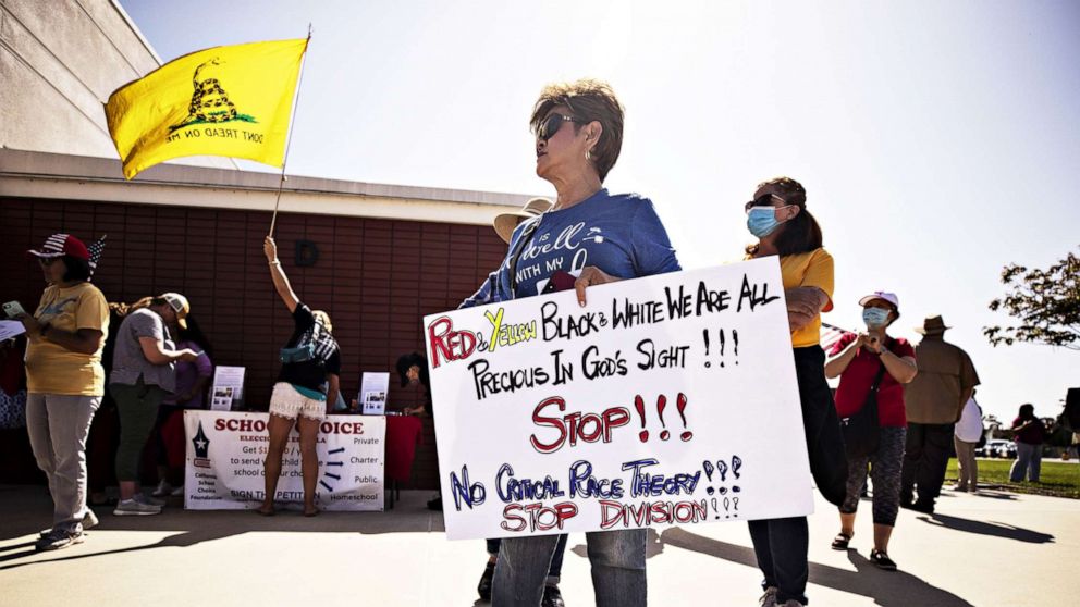 PHOTO: A protester holds a sign reading 'Red and Yellow Black and White We are all Precious in God's Sight! Stop! No Critical Race Theory! Stop Division!' at the Los Alamitos Unified School District building in Los Alamitos, Calif., May 11, 2021.
