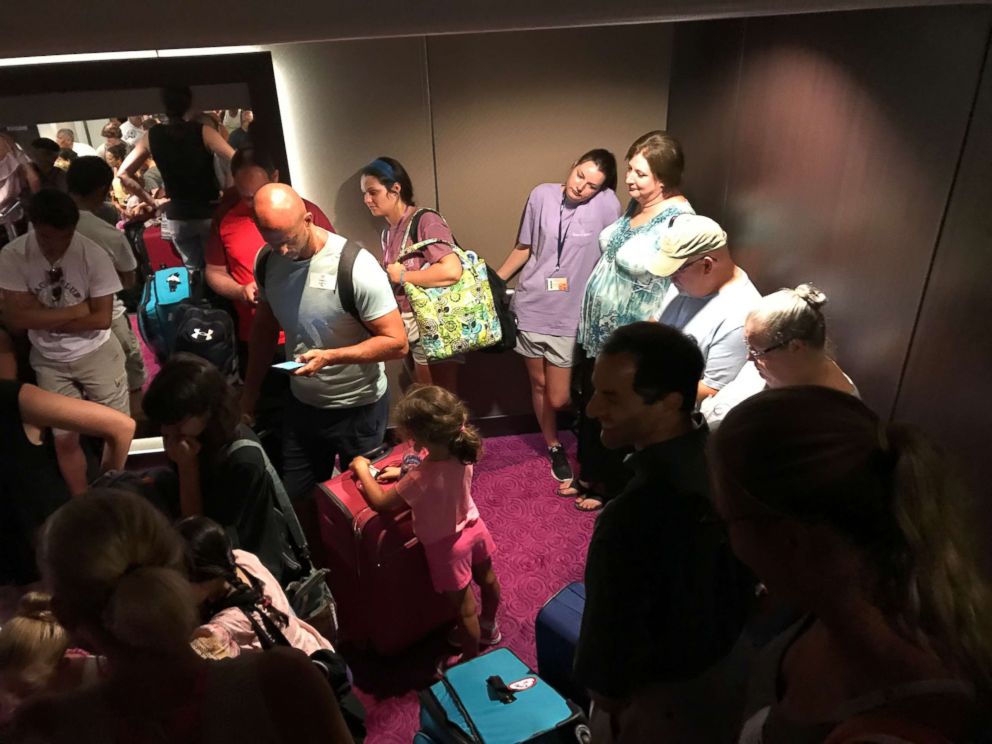 Passengers mill about the Norwegian Getaway while delayed during the search for a crew member who fell overboard on Saturday, June 30, 2018.