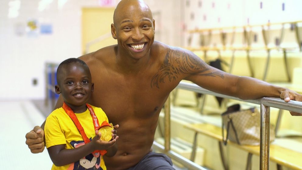 PHOTO: Olympic swimmer Cullen Jones poses with a young child after a swim class in New York.