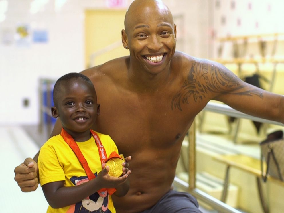 PHOTO: Olympic swimmer Cullen Jones poses with a young child after a swim class in New York.